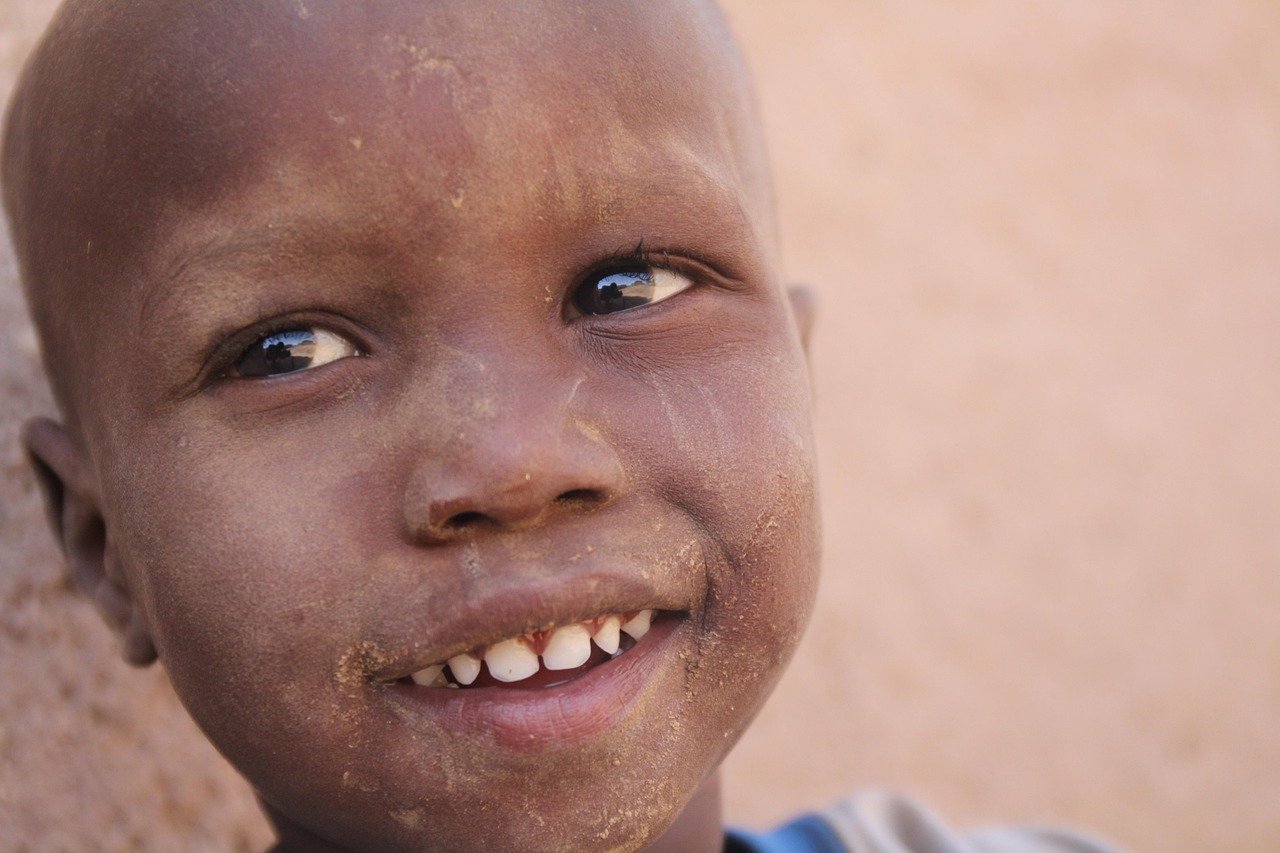 Cepillado infantil: guía completa por edad para crear el hábito Niña jugando mientras se cepilla los dientes con un cepillo colorido en el baño.