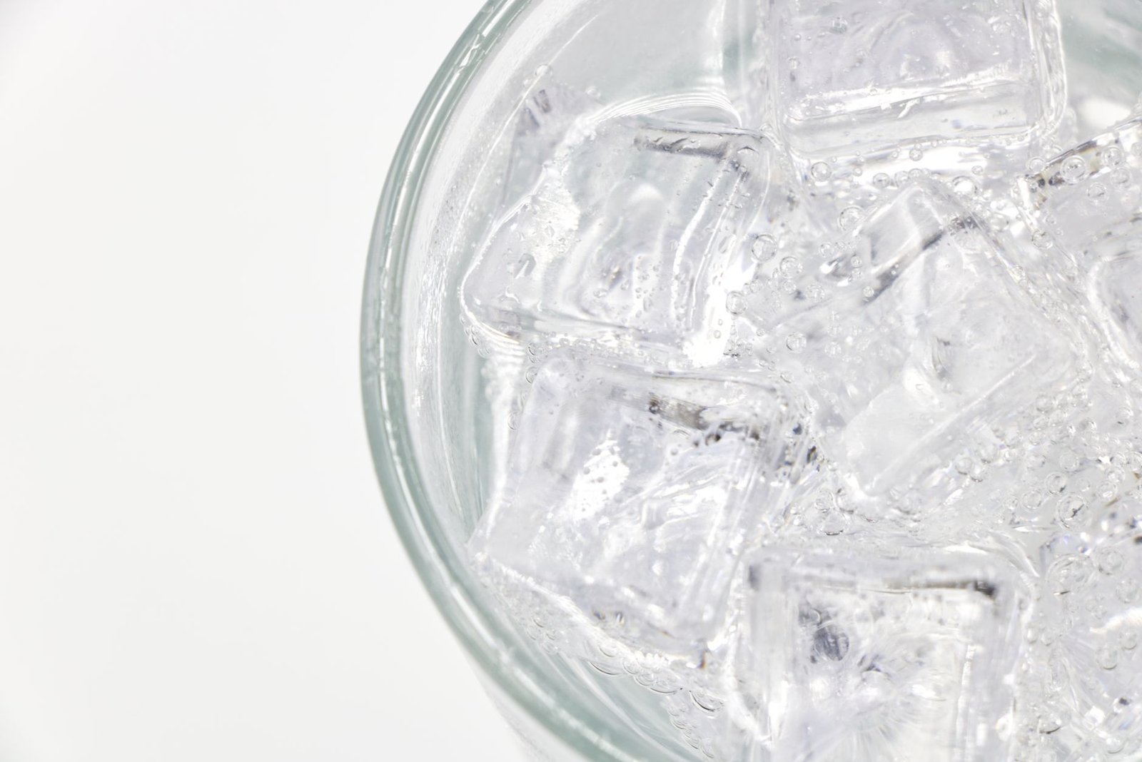 Malos hábitos dentales: seis costumbres que dañan tu boca Cubitos de hielo en un vaso, mostrando la dureza que daña el esmalte dental.