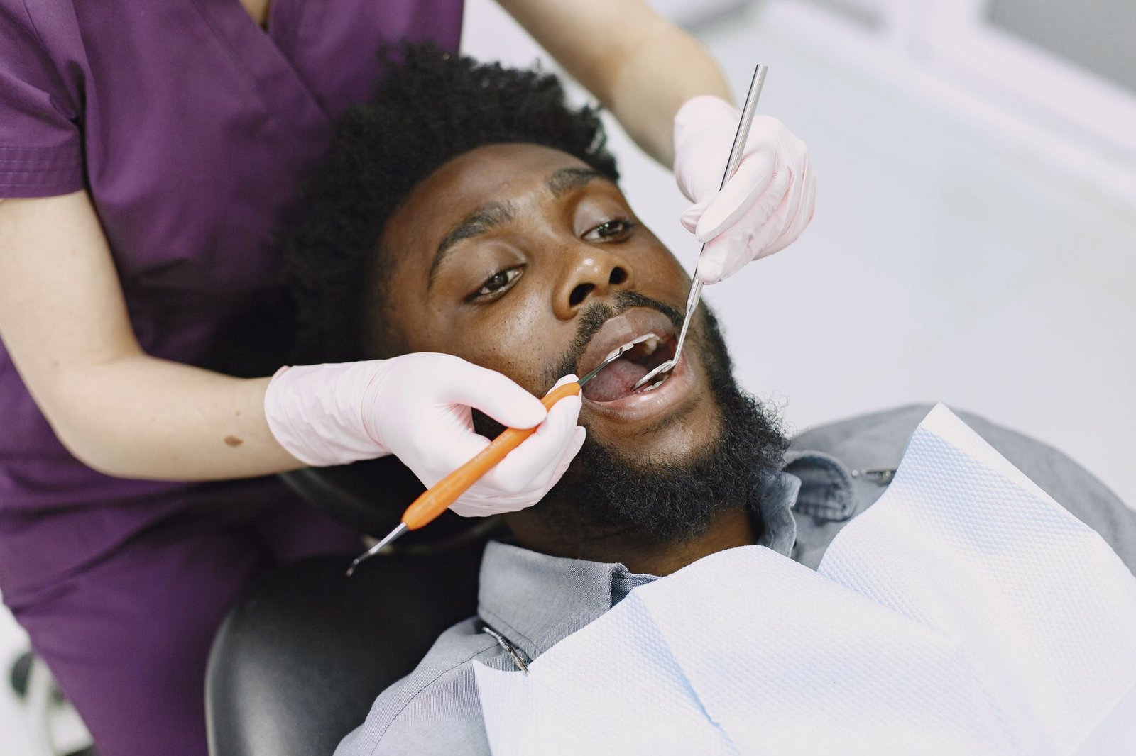Malos hábitos dentales: seis costumbres que dañan tu boca Paciente en la consulta del dentista durante un examen bucal profesional.